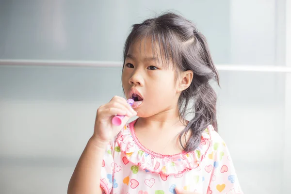 小さなアジアの女の子ブラッシング彼女の歯でバスルーム自己ブラシ歯 — ストック写真