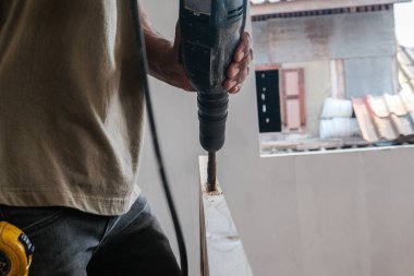 Marangoz yeni evdeki ahşap kapı mobilyası imalatı sırasında ahşap kesme makinesi üzerinde çalışıyor.