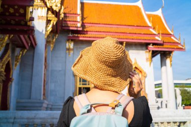 Mutlu Asyalı turist kadınlar Buda tapınağında yürürken Bangkok Tayland 'da şapka takıyor.