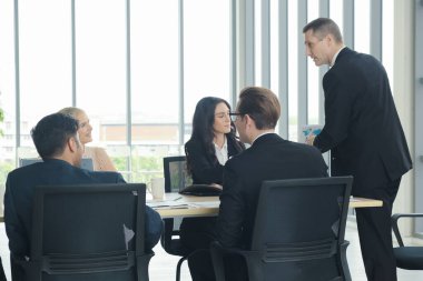 Çeşitli milliyetten iş adamları ve iş kadınları modern ofiste takım tartışması başlamıştır.