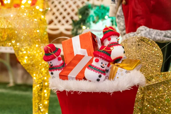 Glücklich Lächelnde Schneepuppe Mit Geschenkbox Auf Weihnachtsdekoration Hintergrund Mit Bokeh — Stockfoto