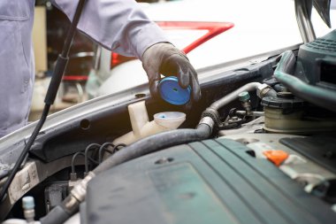 Tamirci, araba motoru radyatörünün bakım konseptini kontrol ediyor.