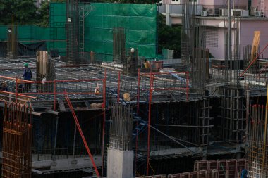 İnşaat mühendisi ve mekanik ekip inşaat halindeki vinç ve binalarla çalışıyor.