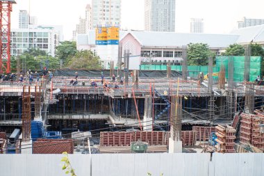 İnşaat mühendisi ve mekanik ekip inşaat halindeki vinç ve binalarla çalışıyor.