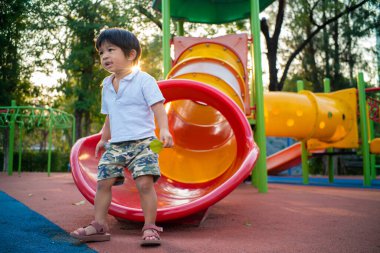 Okul öncesi küçük çocuk şehir parkında oyun parkında sürgülü oynuyordu.