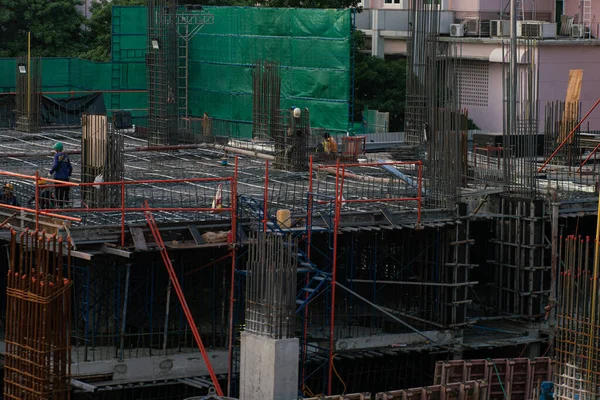 İnşaat mühendisi ve mekanik ekip inşaat halindeki vinç ve binalarla çalışıyor.