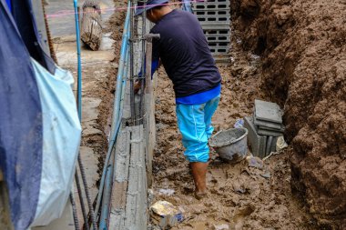 Açık havada tuğla duvar inşaatında mekanik yapı ustası.