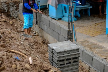 Açık havada tuğla duvar inşaatında mekanik yapı ustası.