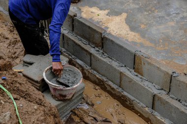 Açık havada tuğla duvar inşaatında mekanik yapı ustası.