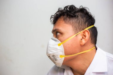Asyalı erkekler n95 maske takıyor. Cauvid 19 'u koru. Beyaz arka plana yakından bak.