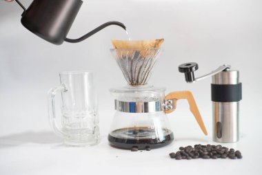 Beyaz arka planda el yapımı Arabika kahvesi damlıyor.