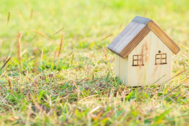 Çim arka plan, gayrimenkul ve emlak konsepti üzerine modern minyatür ahşap ev modeli