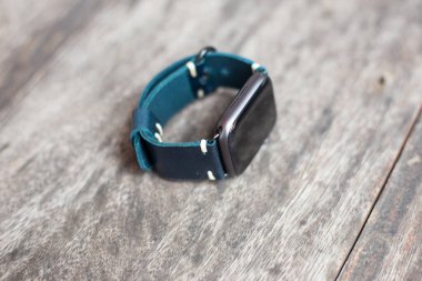 Lacivert deri saat askısı ve tahtada dijital saat.