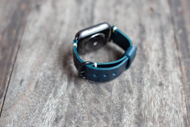 Lacivert deri saat askısı ve tahtada dijital saat.