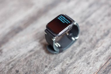 Siyah deri saat kayışı el işçiliği ahşap arka plan üzerinde çalışıyor.