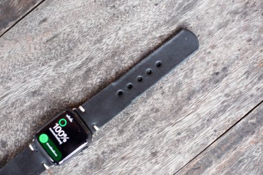 Siyah deri saat kayışı el işçiliği ahşap arka plan üzerinde çalışıyor.