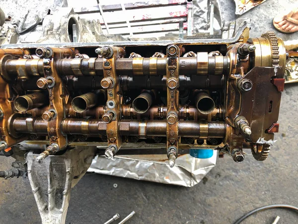 機械男はガレージのスタンドで修理のために対向車のエンジンを解体します 視野内の車のエンジンを閉じます — ストック写真