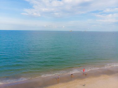 Deniz sahili beyaz kumsalı, dalgalı turkuaz deniz suyu, hava manzaralı.