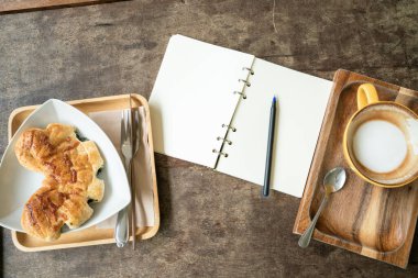 Üzerinde kahve fincanı olan defter metni ahşap masa işi düşünce konsepti