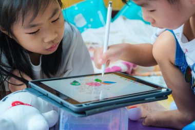 Anaokulu çocuğu evde sosyal uzaklık öğrenirken resim yapmak için tablet kullanıyor