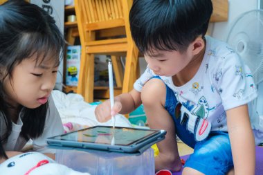 Anaokulu çocuğu evde sosyal uzaklık öğrenirken resim yapmak için tablet kullanıyor