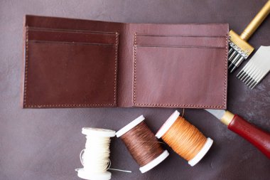 Esmer, hakiki deri erkek cüzdanı ve el işi aleti.