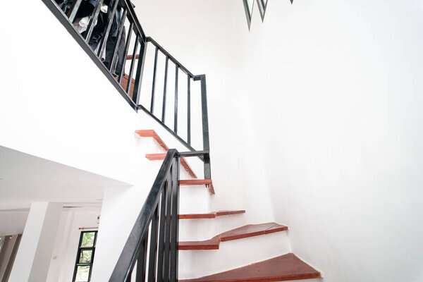 Red brown wooden stair in modern white new house interior building