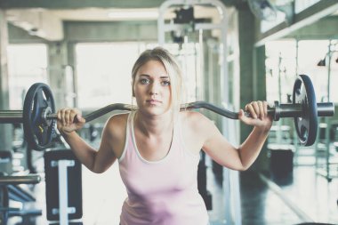 Güzel, akıllı spor kadınları spor salonunda halter kaldırıyor.