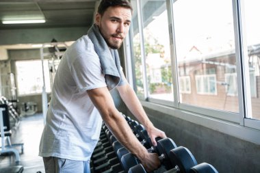 Akıllı sporcu spor salonunda dambılı kaldırıyor. Aktivite eli kapalı.