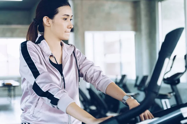 Beautiful smart women exercise with bike in sport fitness gym private gym