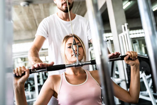 Smart sport women lift up barbell with trainer man in gym healthy concept