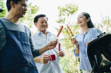 Emekliler evlerinin bahçesinde barbekü partisi veriyor ve mutlu bir son sınıf partisi veriyor.