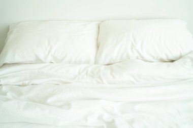 Rahat beyaz yatak odası. İç dekorasyonu sabah ışığıyla minimumda.