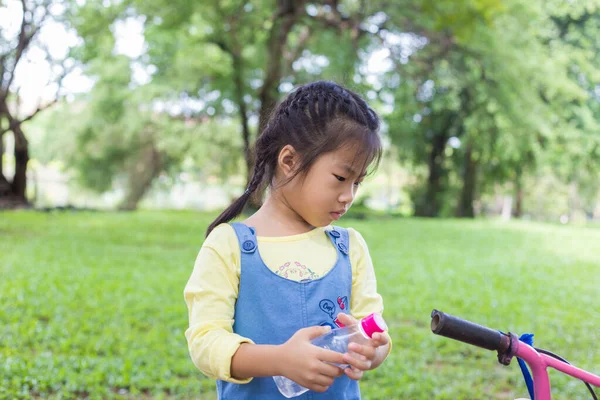 Şehir parkındaki bisikletli sevimli kız egzersizi.