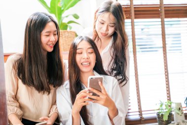 Beautiful asian women with friend use smartphone online shopping in house happy together
