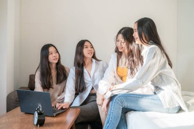 İş ortağı kadınlar, rahat bir odada dizüstü bilgisayarla beyin fırtınası yapmayı düşünüyorlar.