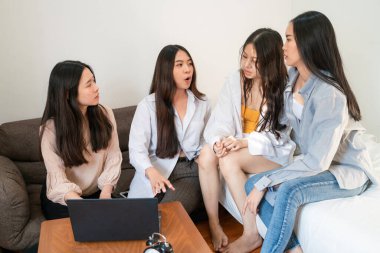 İş ortağı kadınlar, rahat bir odada dizüstü bilgisayarla beyin fırtınası yapmayı düşünüyorlar.