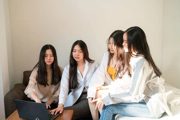 İş ortağı kadınlar, rahat bir odada dizüstü bilgisayarla beyin fırtınası yapmayı düşünüyorlar.