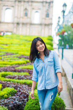 Asya 'lı turist kadınlar Çin' in Macao şehrinde tarihi St. Paul Kilisesi mimarisinin önünde seyahat ediyorlar.