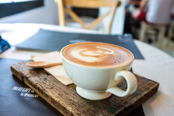 Sıcak latte sanat aromalı kahve, ahşap masa içkisi ve iş.