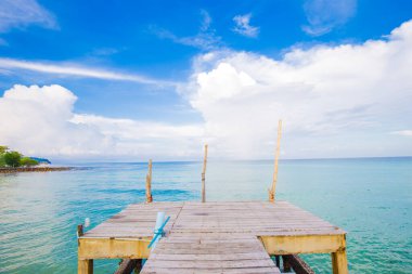 Renkli gökyüzü ile eski ahşap köprüden sahile doğa manzarasını bulutlandırır