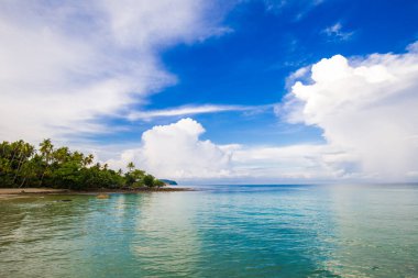 Deniz kıyısı turkuvaz suyunun doğa manzarası bulutlu mavi gökyüzüne karşı yaz tatili