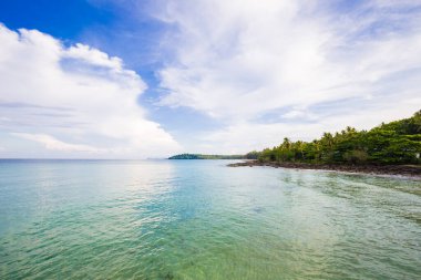 Deniz kıyısı turkuvaz suyunun doğa manzarası bulutlu mavi gökyüzüne karşı yaz tatili