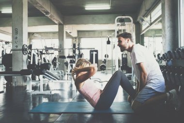 Erkekler ve kadınlar birlikte antrenman yapıyor. Dik otur ve spor salonunda Rectus Abdominis 'i kaslı yap.