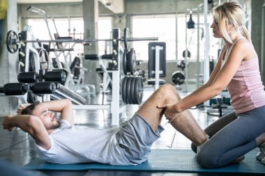 Erkekler karın egzersizleri yapıyor spor salonundaki kadınlara en uygun spor salonu ve sağlıklı yaşam tarzı konsepti.