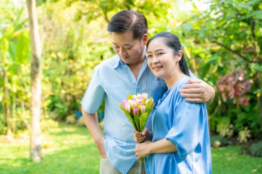 Olgun çiftler, ev bahçesinde çiçek açmaktan mutlu kadınlar.