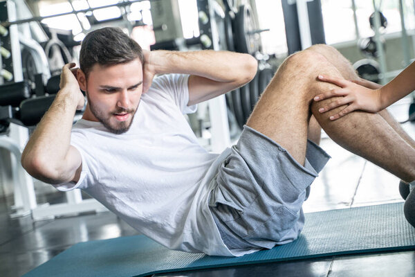 Men and women trainning together sit up make Rectus Abdominis muscular in sport gym