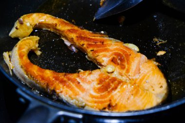 Tavada ızgara somon bifteği ve deniz ürünleri pişirme.