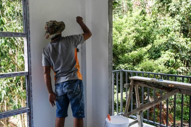 Modern Hpuse bina tasarımı konseptinin içini boyayan mekanik adam.