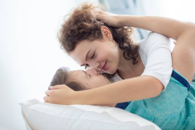 Mutlu bir sabah uyandıktan sonra beyaz yatakta uzanan birkaç aşk kucaklaşması.